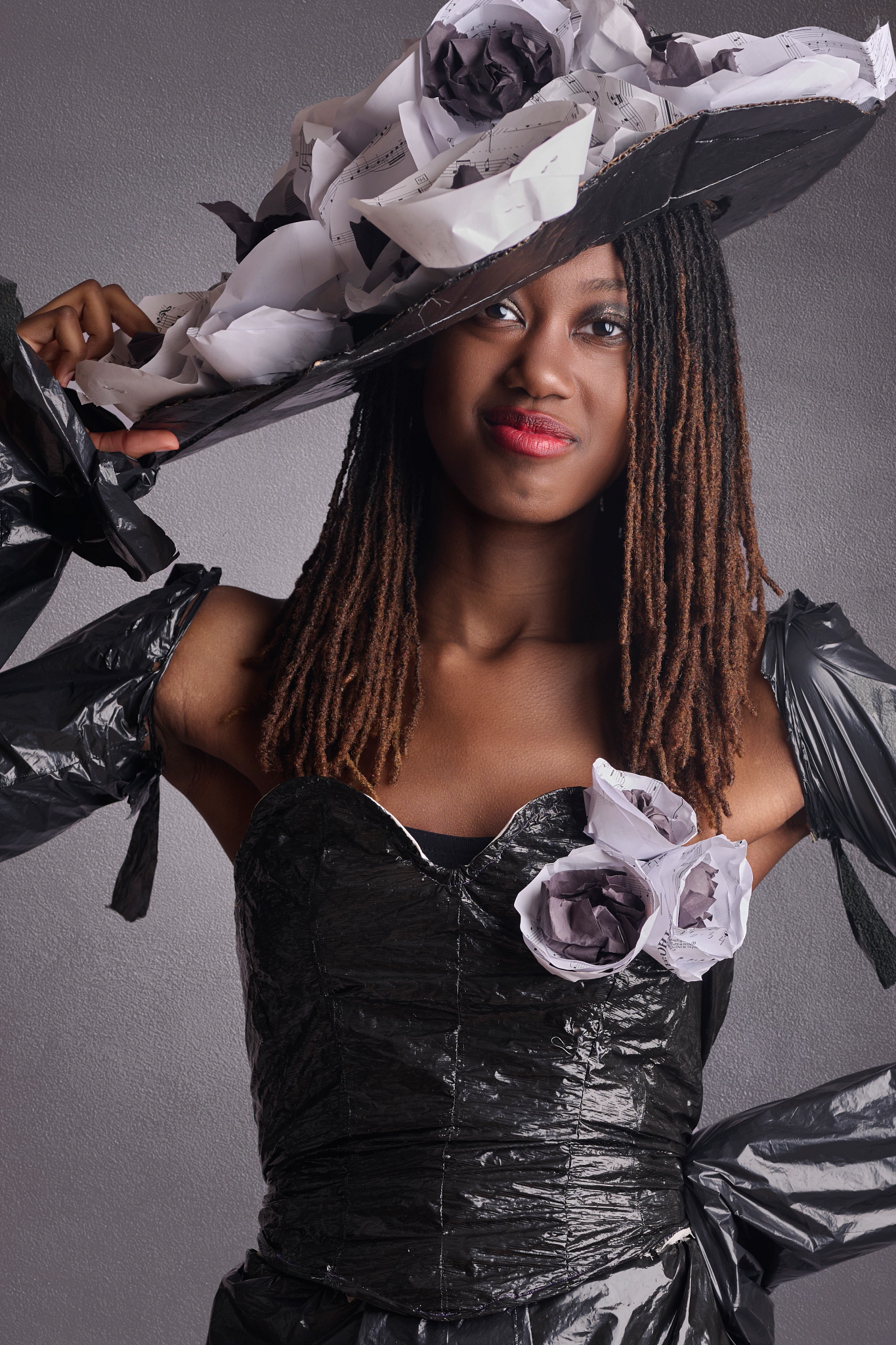 Recycle the Runway. My Fair Lady A student models a black gown and hat made from trash bags and other recycled materials.