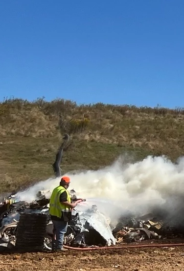 image of a smoky fire with construction trucks in an open space
